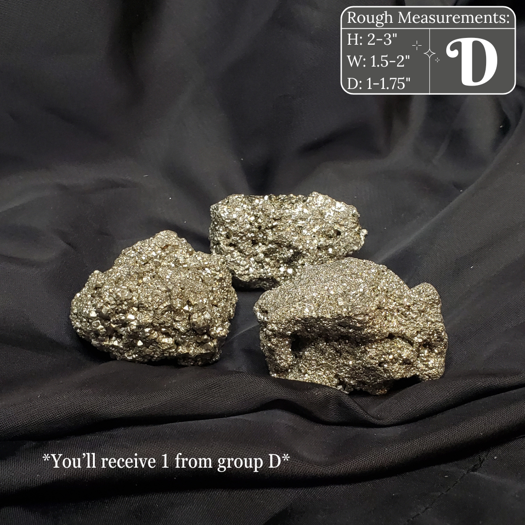 Three metallic pyrite crystals on a black fabric background with measurements and text overlay.