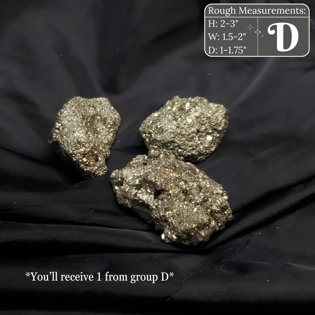 Three metallic pyrite crystals on a black fabric background with measurements and branding details.